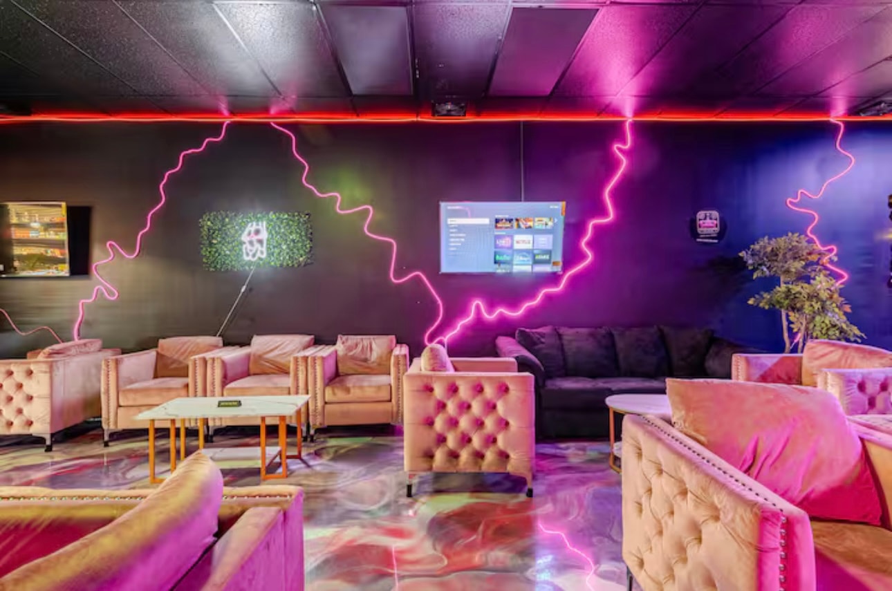 Armchairs and a long sectional under the lounge's neon linework.